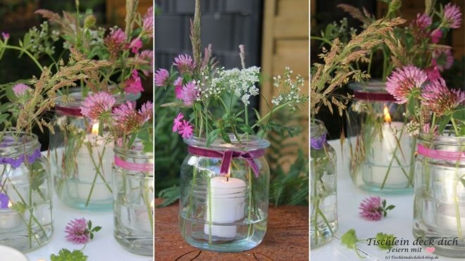 Weckgläser dekoriert mit Wiesenblumen und Kerze