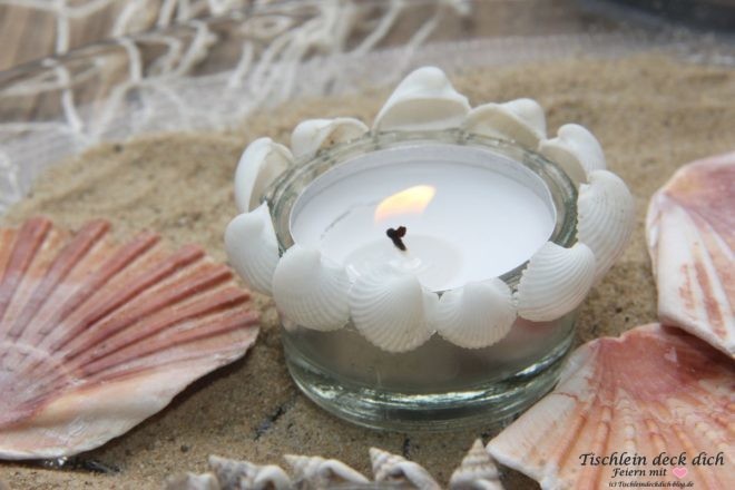 Kerzdendeko mit kleinen Muscheln und Teelichtgläsern