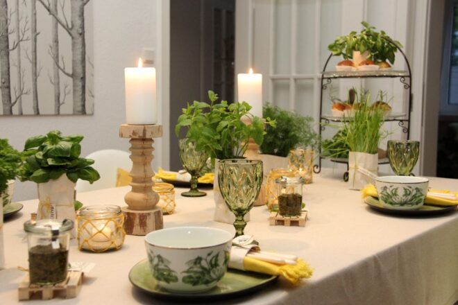 Tischdekoration fruehlingshaft in gelb gruen mit rustikalem Geschrirr und gruenen Glaesern