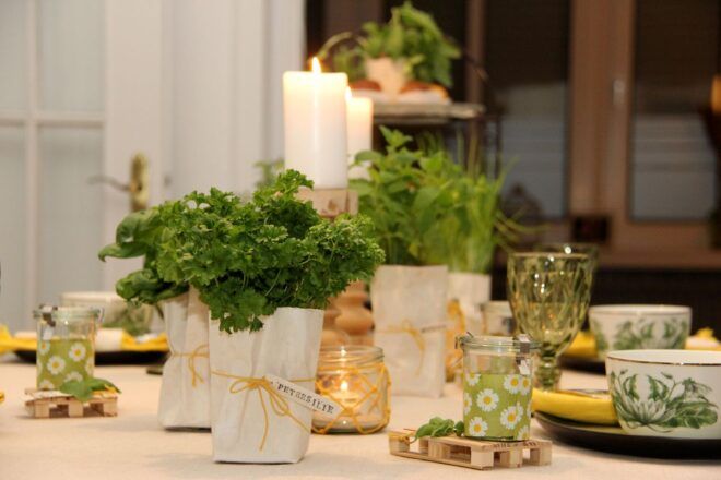 Fruehlingshafte Tischdekoidee in den Farben gelb und gruen mit frischen Krauetern