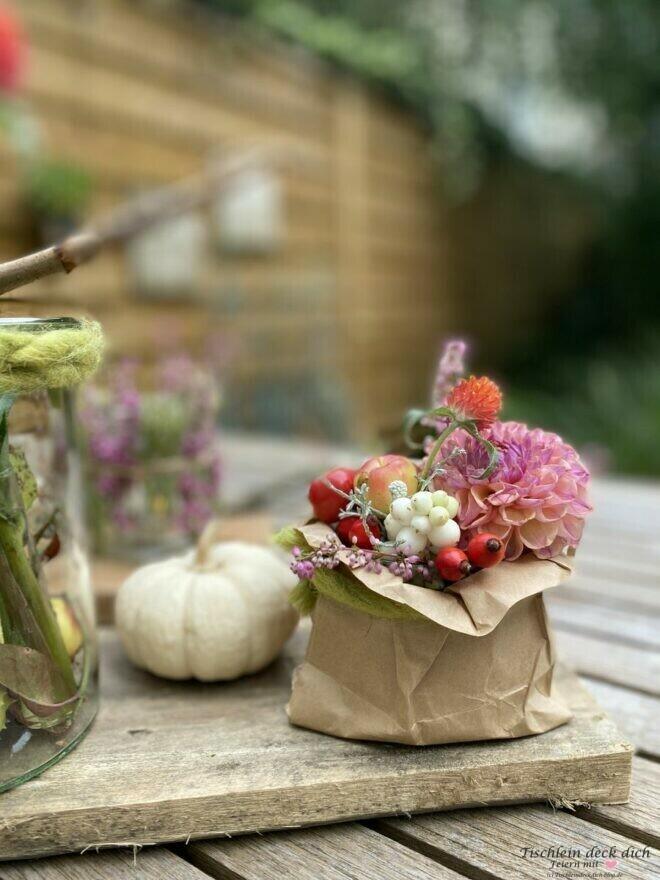 Herbstdekoration, Blumengesteck im Glas mit Packpapiertüte