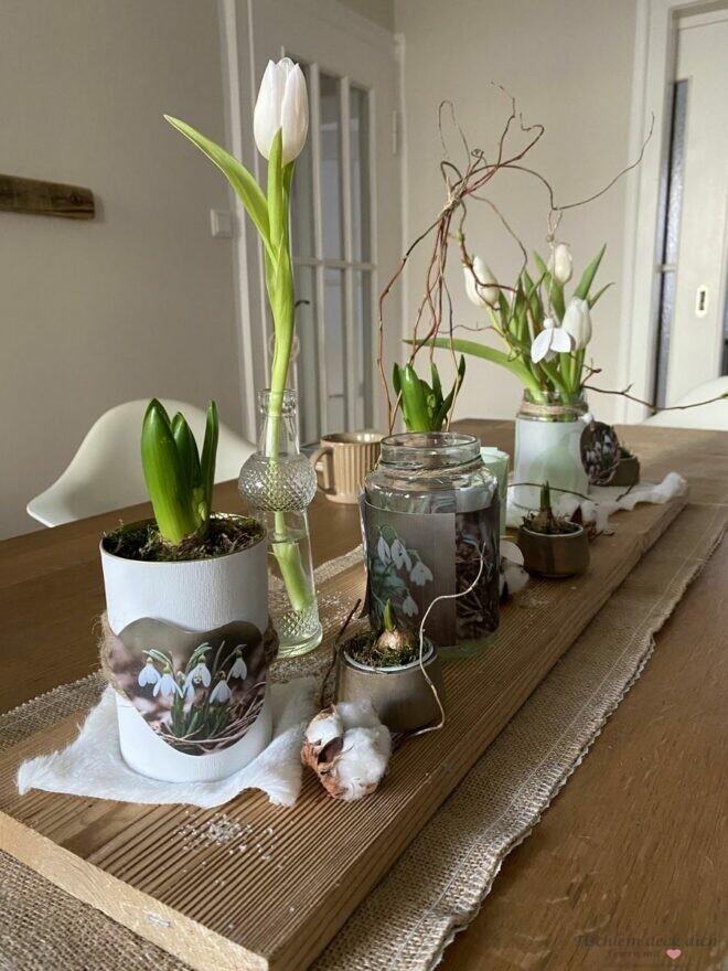 Frühlingsdekoration auf einem langen Holzbrett für den Tisch