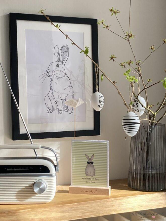 Konsole aus Eiche mit Radio Osterzweigen mit schwarz weißen Eiern und Osterhasedruck in schwarz weiß im schwarzen Rahmen