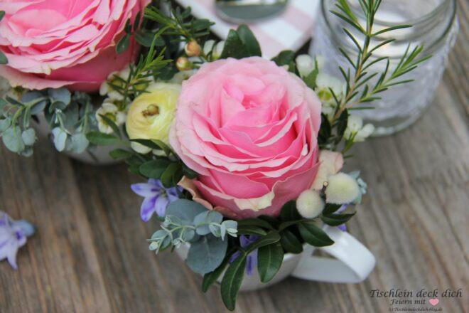 Suesse Blumendeko zum Muttertag mit pinker Rose in weißer Kaffeetasse