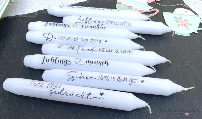 weiße Kerzen mit Kerzentatoos verziert, mit sogenannter Wasserschiebefolie