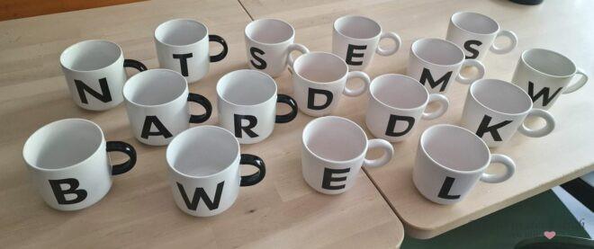 schwarz weiße Tassen mit Buchstaben