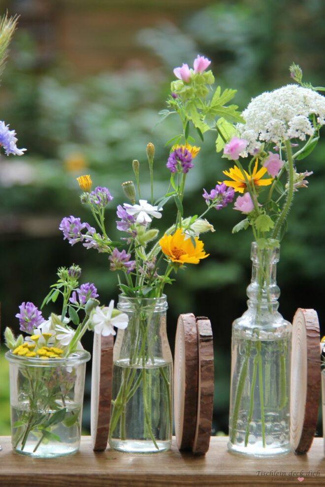Wiesenblumen Arrangement auf Holzbrett mit Baumscheiben
