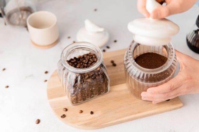 Kaffeebohnen und Kaffeepulver in dekorativen Gläsern