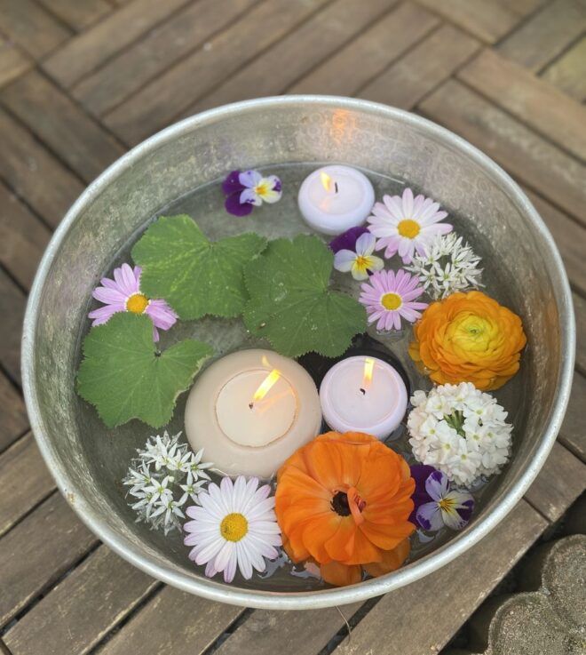 Schwimmkerzen und Blüten in großer Schale