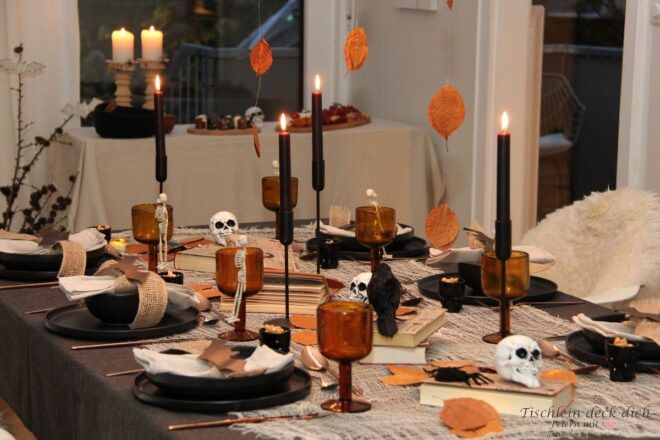 Tischdekoration für Halloween mit alten Büchern und Totenköpfen